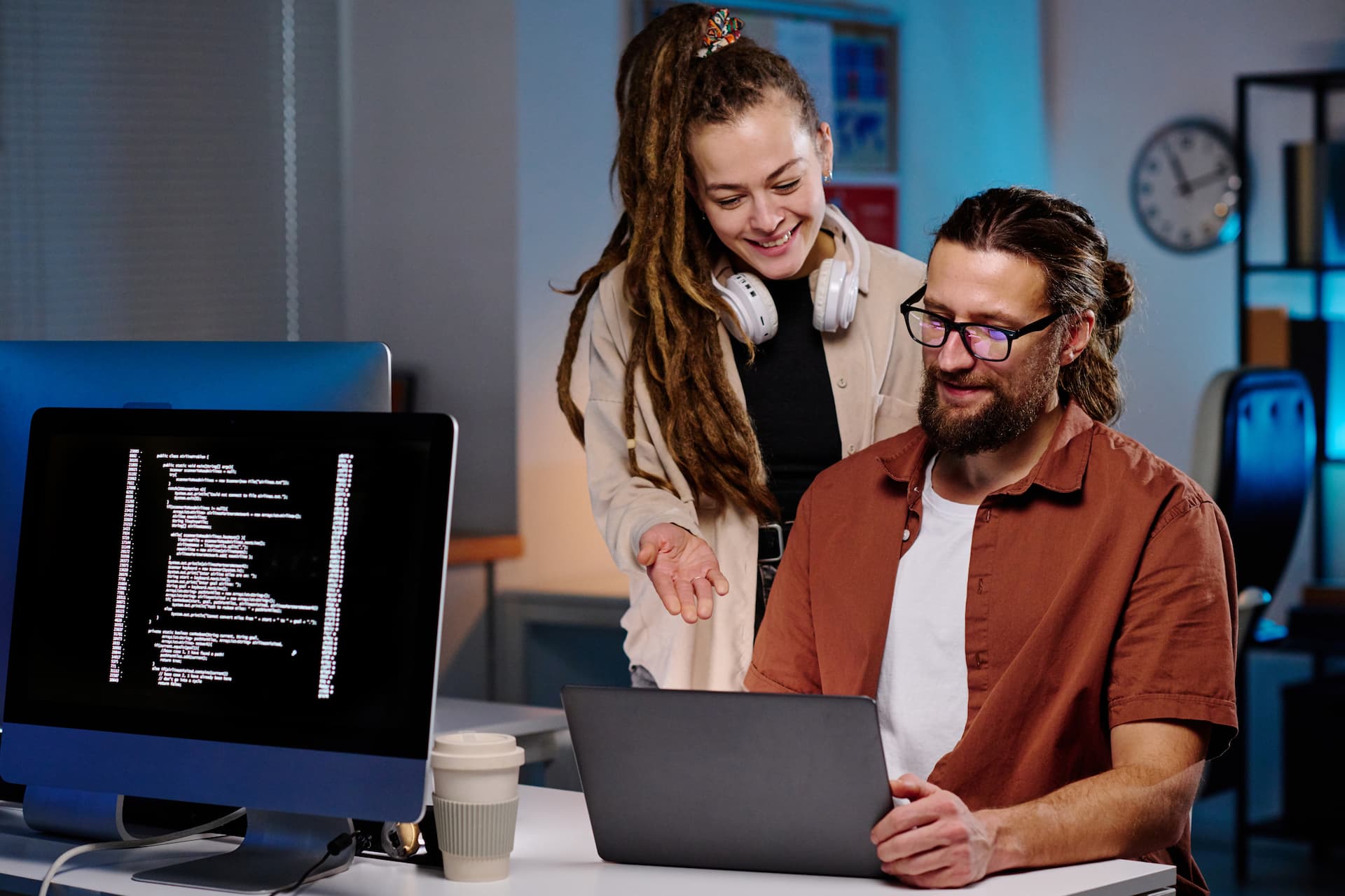 Mulher sorrindo apontando para a tela de um notebook
