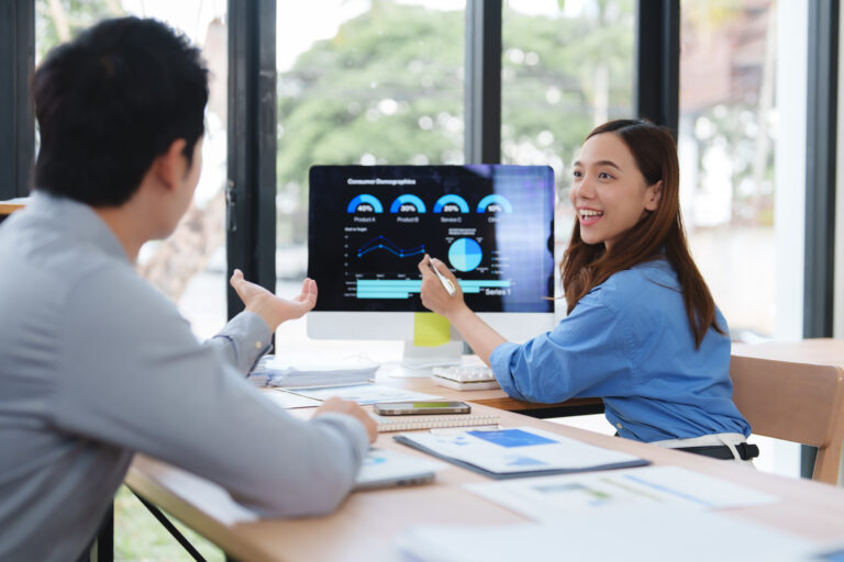 Executiva mostrando gráfico de resultados no computador